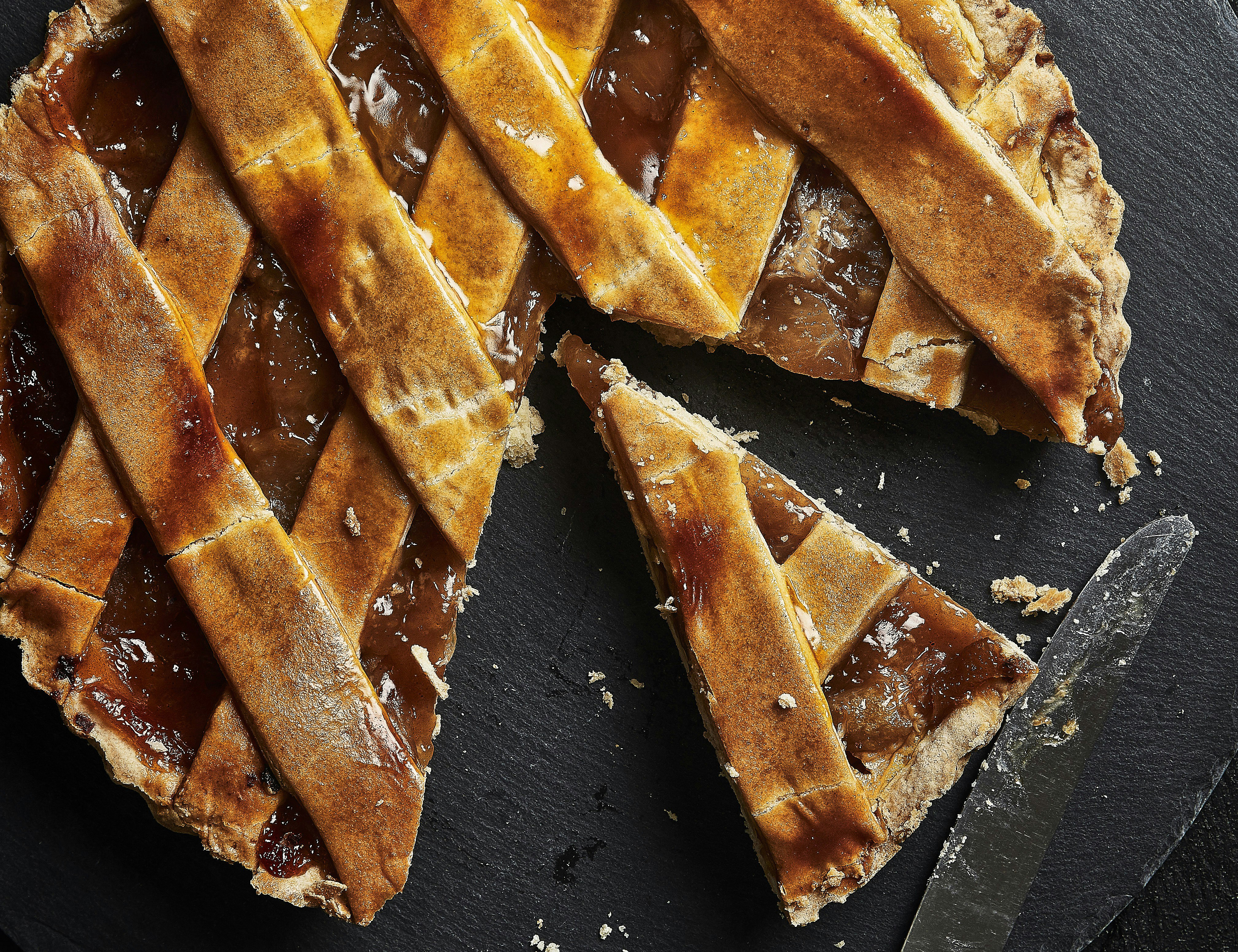 pie on a black plate with a single slice cut from it
